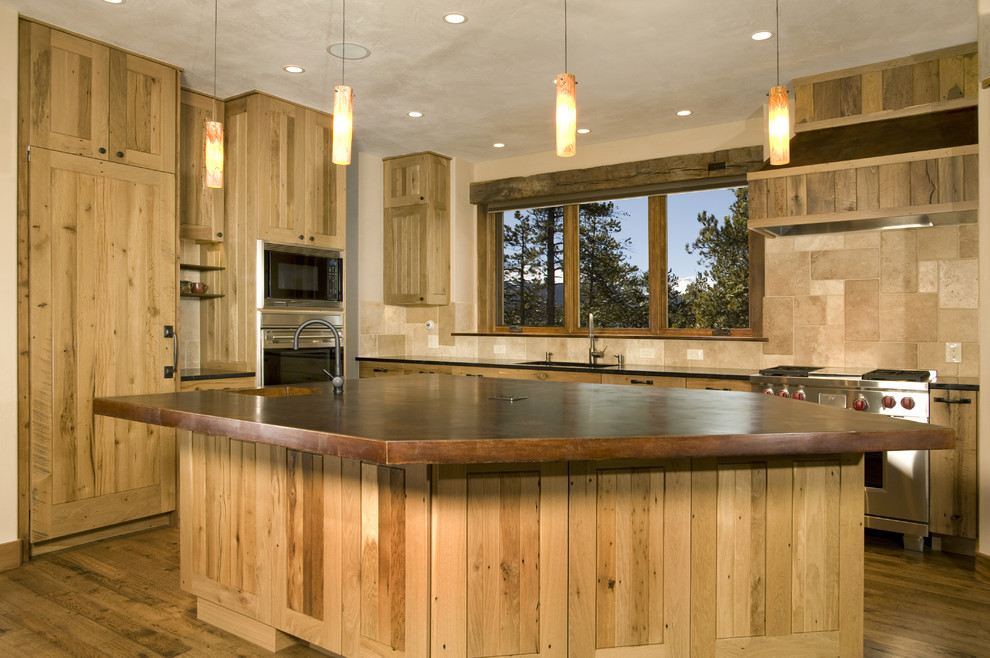 Inspiration for a large rustic l-shaped medium tone wood floor eat-in kitchen remodel in Denver with stainless steel appliances, an island, light wood cabinets, a drop-in sink, flat-panel cabinets, wood countertops, beige backsplash and ceramic backsplash