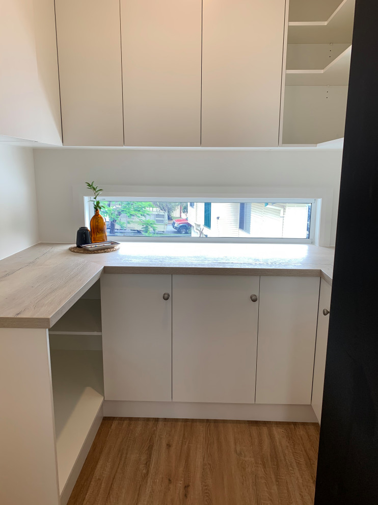 Kleine Küche ohne Insel in U-Form mit Vorratsschrank, Laminat-Arbeitsplatte, Rückwand-Fenster, Vinylboden und buntem Boden in Brisbane