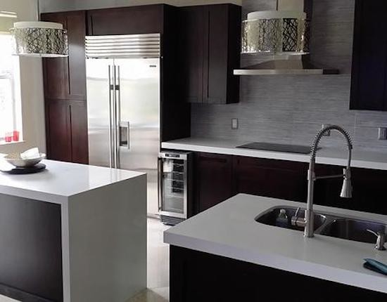 Enclosed kitchen - small l-shaped enclosed kitchen idea in Miami with a double-bowl sink, raised-panel cabinets, white cabinets, granite countertops, metallic backsplash, stone tile backsplash, white appliances and an island