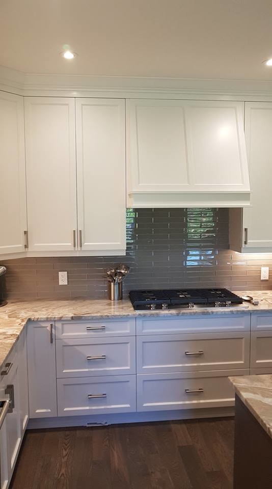 This is an example of a large traditional l-shaped kitchen/diner in Vancouver with shaker cabinets, white cabinets, granite worktops, grey splashback, brown worktops, a submerged sink, stainless steel appliances, an island, brown floors, ceramic splashback and medium hardwood flooring.
