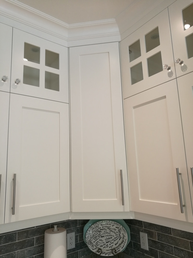 Bild på ett mellanstort vintage vit vitt kök, med skåp i shakerstil, vita skåp, grått stänkskydd, en undermonterad diskho, bänkskiva i kvarts, stänkskydd i stenkakel, rostfria vitvaror, ljust trägolv, en köksö och beiget golv