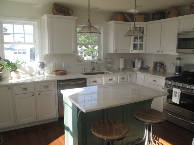 Foto på ett mellanstort maritimt kök, med vita skåp, granitbänkskiva, rostfria vitvaror, mörkt trägolv och en köksö