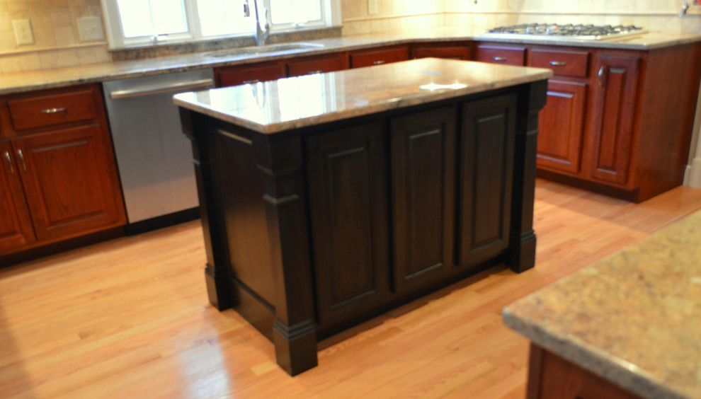 Exempel på ett mellanstort klassiskt l-kök, med en undermonterad diskho, luckor med upphöjd panel, skåp i mörkt trä, granitbänkskiva, beige stänkskydd, stänkskydd i keramik, ljust trägolv och en köksö