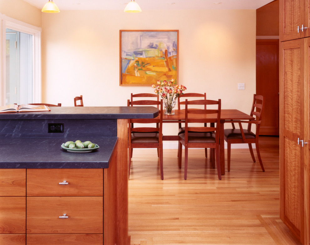 Imagen de cocina de estilo americano con armarios estilo shaker, puertas de armario de madera oscura, encimera de esteatita y barras de cocina