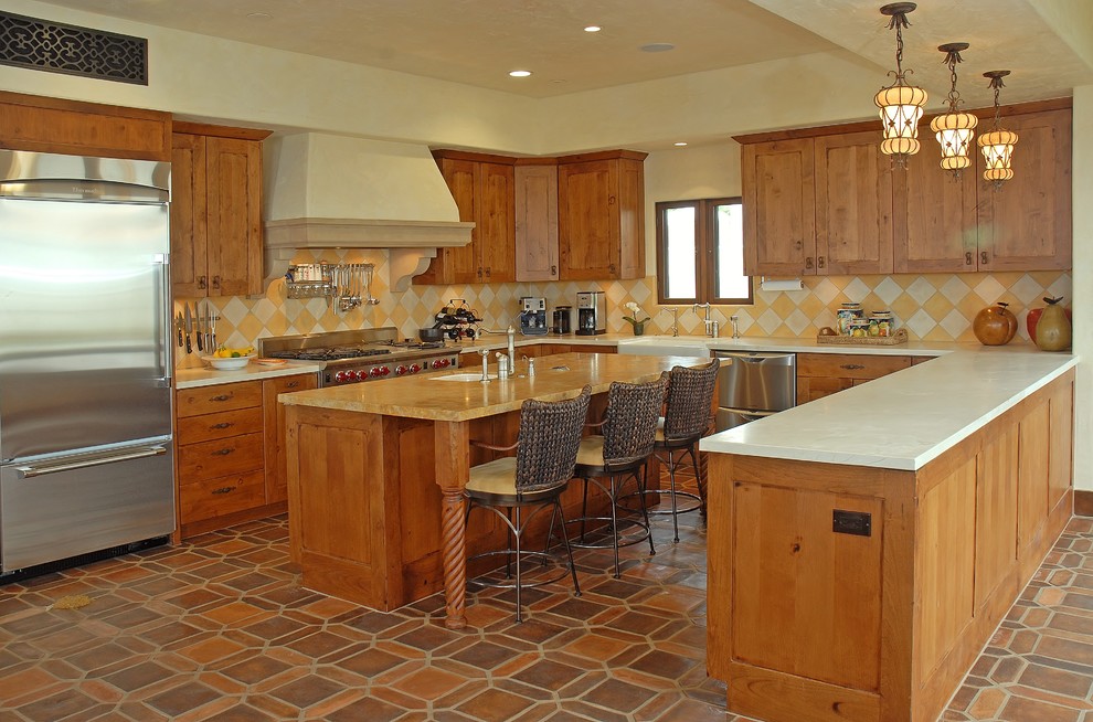 Open concept kitchen - large mediterranean u-shaped terra-cotta tile and brown floor open concept kitchen idea in San Diego with a farmhouse sink, shaker cabinets, medium tone wood cabinets, multicolored backsplash, ceramic backsplash, stainless steel appliances, an island and solid surface countertops
