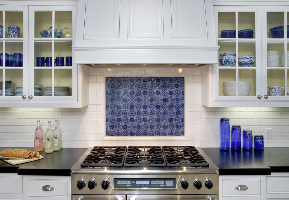 Shabby-Look Küche mit weißen Schränken, Küchenrückwand in Weiß, Rückwand aus Metrofliesen, Küchengeräten aus Edelstahl, braunem Holzboden und Kücheninsel in San Diego