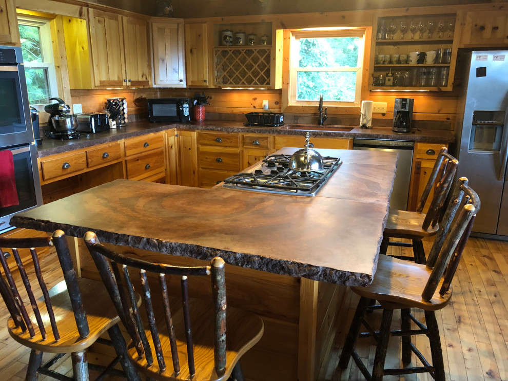 Idéer för att renovera ett mellanstort rustikt brun brunt kök, med en rustik diskho, bänkskiva i betong, gult stänkskydd, stänkskydd i trä, rostfria vitvaror, en köksö, skåp i shakerstil, skåp i ljust trä och ljust trägolv