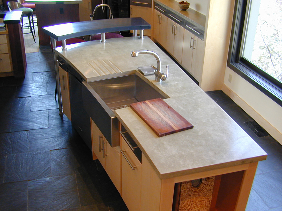 Cette photo montre une cuisine américaine linéaire moderne avec un évier encastré et un plan de travail en béton.