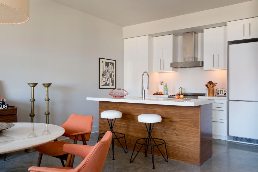 Esempio di una cucina minimal con ante lisce, ante bianche, elettrodomestici bianchi, pavimento in cemento, pavimento grigio e top bianco