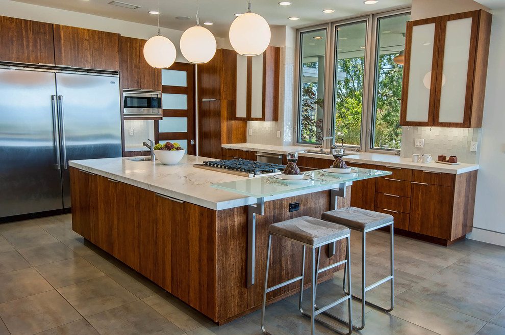 Immagine di una cucina a L design con lavello sottopiano, ante lisce, ante in legno bruno, paraspruzzi bianco e elettrodomestici in acciaio inossidabile