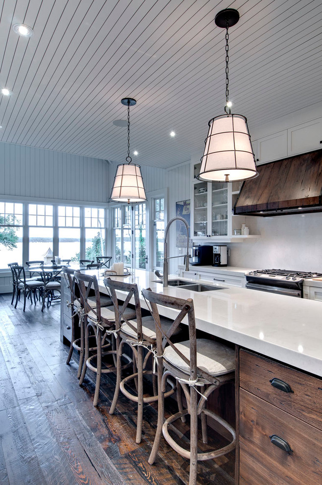 Example of a beach style dark wood floor eat-in kitchen design in Toronto with a double-bowl sink, flat-panel cabinets, dark wood cabinets, white backsplash and an island