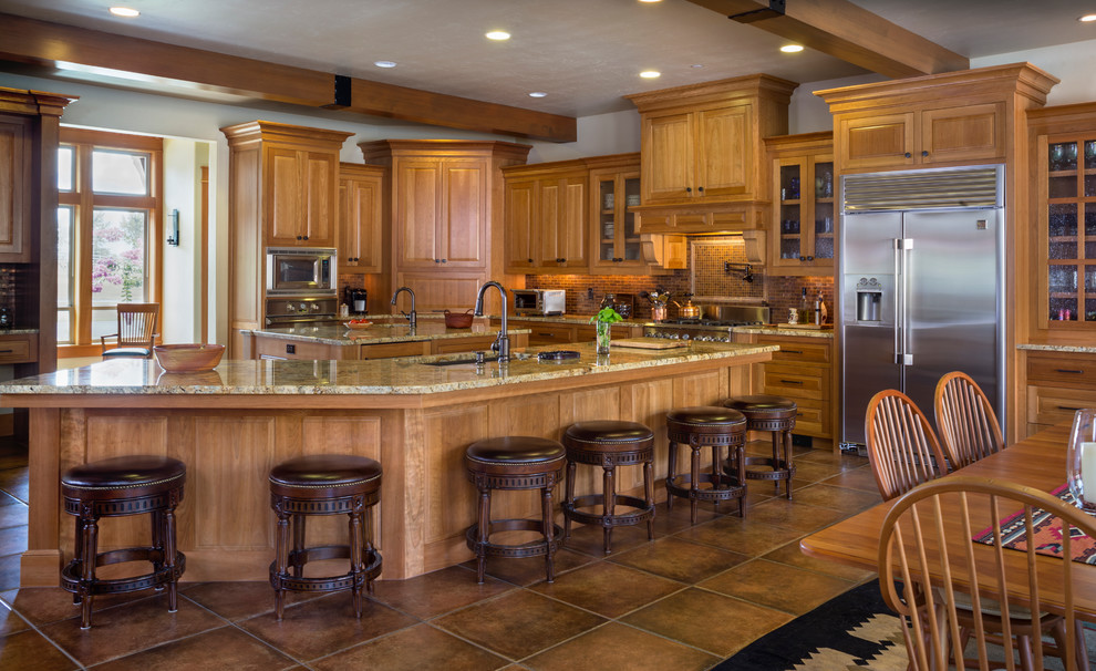 ポートランドにあるトラディショナルスタイルのおしゃれなキッチン (アンダーカウンターシンク、レイズドパネル扉のキャビネット、中間色木目調キャビネット、茶色いキッチンパネル、モザイクタイルのキッチンパネル、シルバーの調理設備、茶色い床、ベージュのキッチンカウンター) の写真