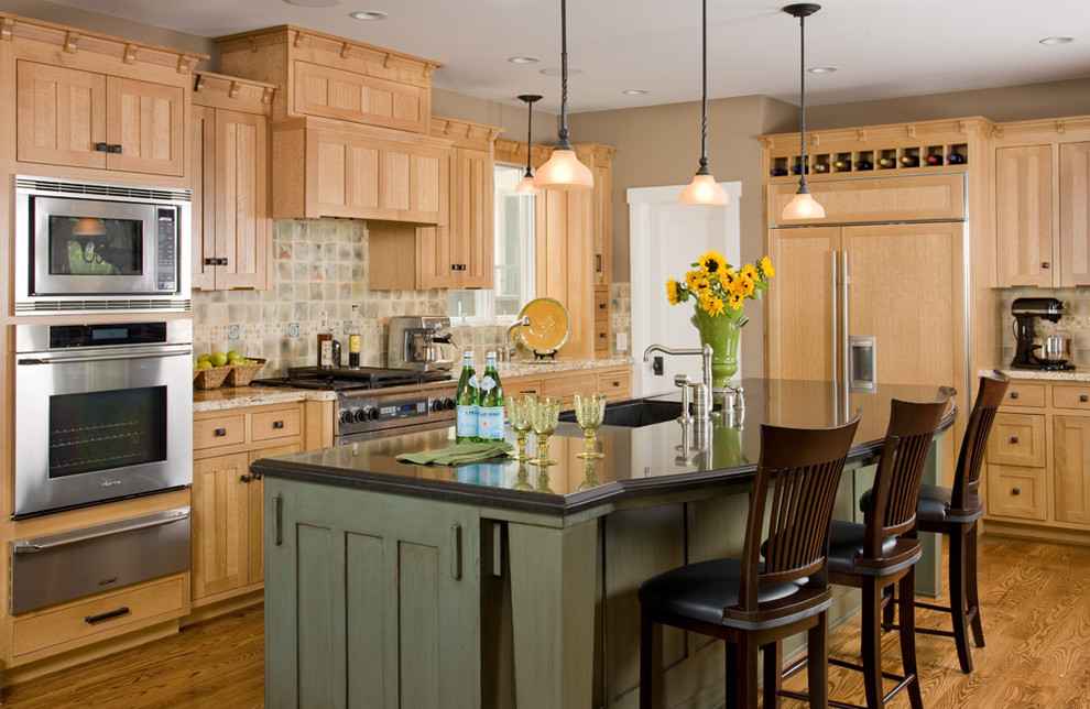 Diseño de cocina tradicional con electrodomésticos con paneles, armarios con paneles empotrados, puertas de armario de madera clara y barras de cocina