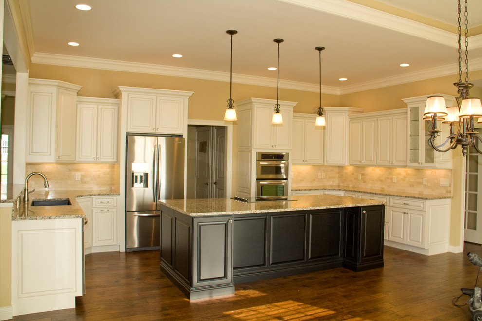 Eat-in kitchen - traditional l-shaped eat-in kitchen idea in Indianapolis with an undermount sink, flat-panel cabinets, white cabinets, granite countertops, beige backsplash, stone tile backsplash and stainless steel appliances