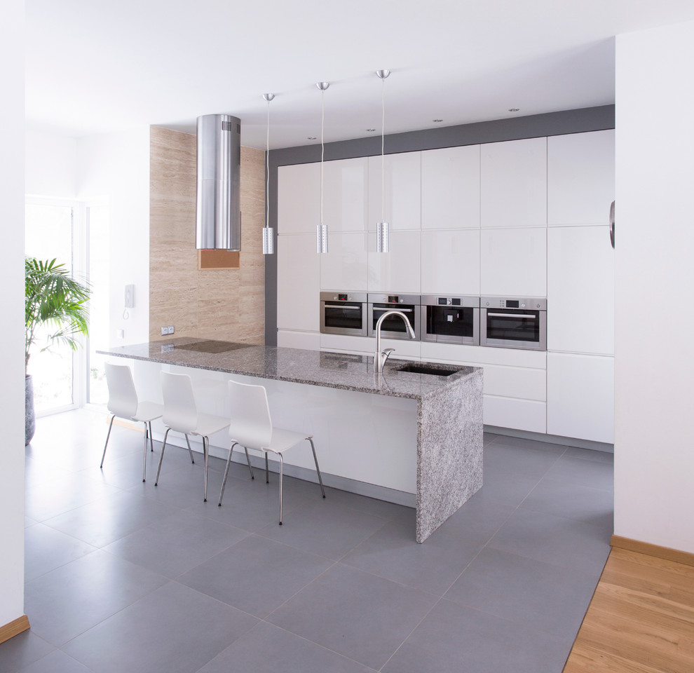 Foto på ett mellanstort funkis kök, med en nedsänkt diskho, luckor med infälld panel, vita skåp, marmorbänkskiva, rostfria vitvaror, klinkergolv i keramik och en köksö