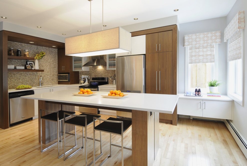 Moderne Küche in L-Form mit Küchengeräten aus Edelstahl, Unterbauwaschbecken, flächenbündigen Schrankfronten, hellbraunen Holzschränken, Küchenrückwand in Braun und Rückwand aus Mosaikfliesen in Calgary