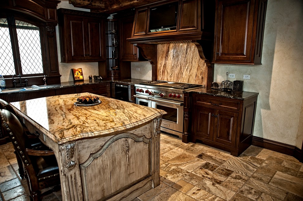 Klassisk inredning av ett stort kök, med en undermonterad diskho, öppna hyllor, skåp i mörkt trä, granitbänkskiva, flerfärgad stänkskydd, stänkskydd i sten, rostfria vitvaror, kalkstensgolv och en köksö