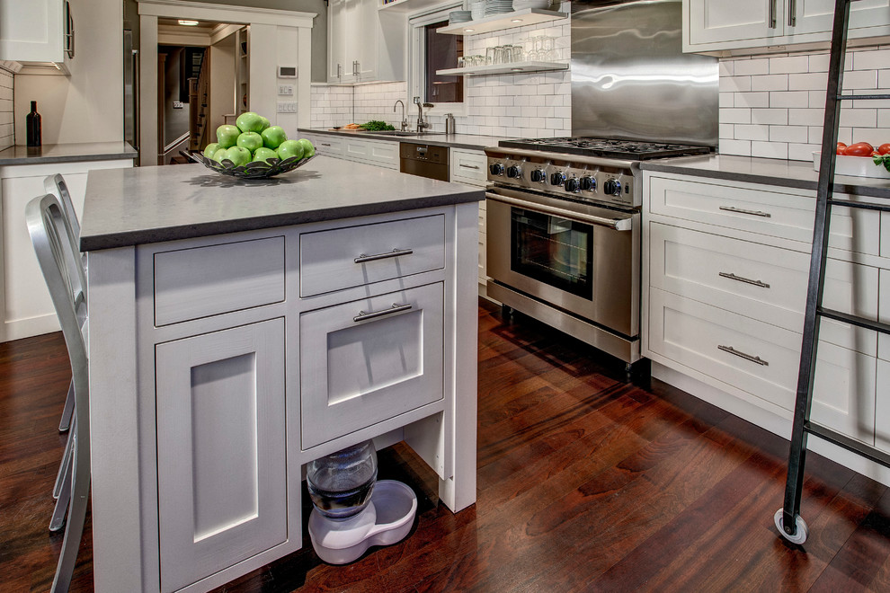 Kitchen - craftsman kitchen idea in Seattle with shaker cabinets, white cabinets, white backsplash, subway tile backsplash, stainless steel appliances and an island