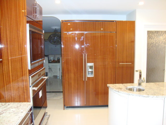 Example of a large trendy l-shaped porcelain tile enclosed kitchen design in Philadelphia with an undermount sink, flat-panel cabinets, dark wood cabinets, granite countertops, red backsplash, ceramic backsplash, stainless steel appliances and an island