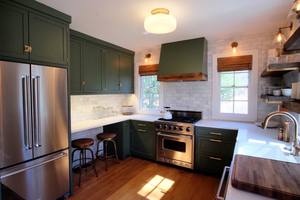 ニューヨークにある高級な小さなカントリー風のおしゃれなキッチン (エプロンフロントシンク、シェーカースタイル扉のキャビネット、緑のキャビネット、大理石カウンター、白いキッチンパネル、セラミックタイルのキッチンパネル、シルバーの調理設備、無垢フローリング、アイランドなし、茶色い床、白いキッチンカウンター) の写真