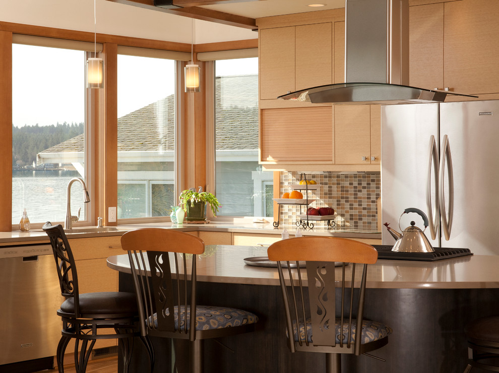Example of a mid-sized trendy l-shaped light wood floor eat-in kitchen design in Seattle with an undermount sink, flat-panel cabinets, light wood cabinets, beige backsplash, stainless steel appliances, an island and mosaic tile backsplash