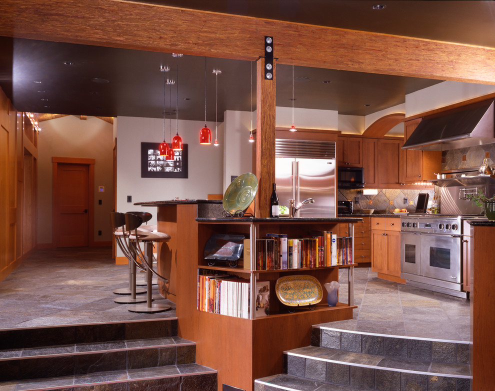 Inspiration for a mid-sized rustic u-shaped enclosed kitchen remodel in Seattle with recessed-panel cabinets, medium tone wood cabinets, granite countertops, gray backsplash, stone tile backsplash, stainless steel appliances and an island
