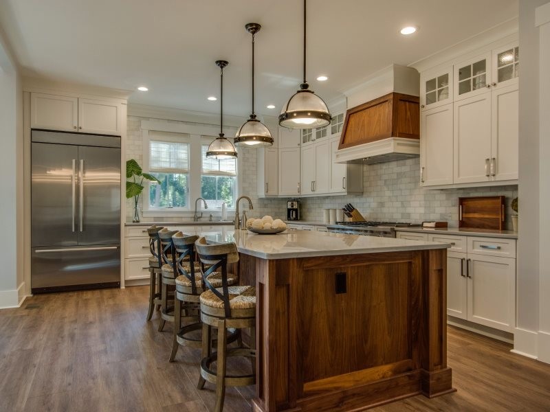 Eat-in kitchen - large eclectic l-shaped medium tone wood floor and brown floor eat-in kitchen idea in Other with an undermount sink, shaker cabinets, white cabinets, granite countertops, gray backsplash, subway tile backsplash, stainless steel appliances, an island and gray countertops