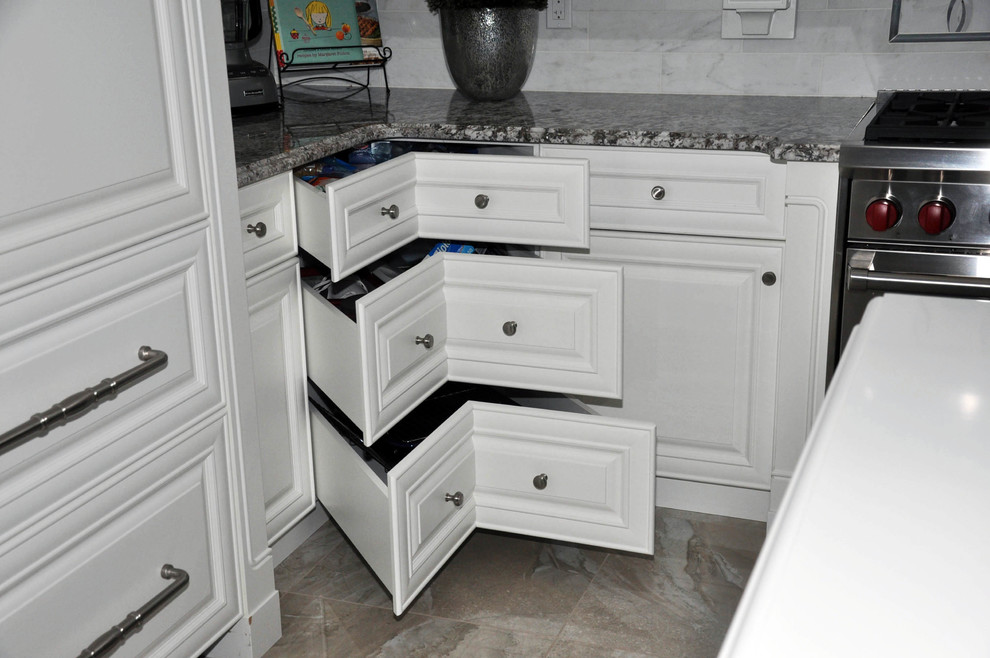 Exempel på ett stort klassiskt kök, med en undermonterad diskho, luckor med upphöjd panel, vita skåp, bänkskiva i kvartsit, vitt stänkskydd, stänkskydd i porslinskakel, vita vitvaror, travertin golv och en köksö