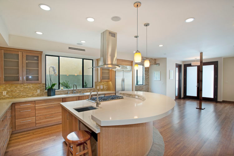 Moderne Wohnküche mit hellen Holzschränken und Küchengeräten aus Edelstahl in Los Angeles