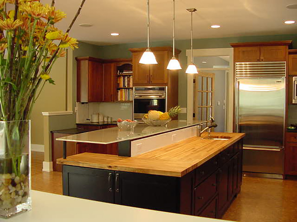 Large arts and crafts u-shaped cork floor eat-in kitchen photo in Chicago with glass countertops, white backsplash, subway tile backsplash, stainless steel appliances, an undermount sink, shaker cabinets, medium tone wood cabinets and an island