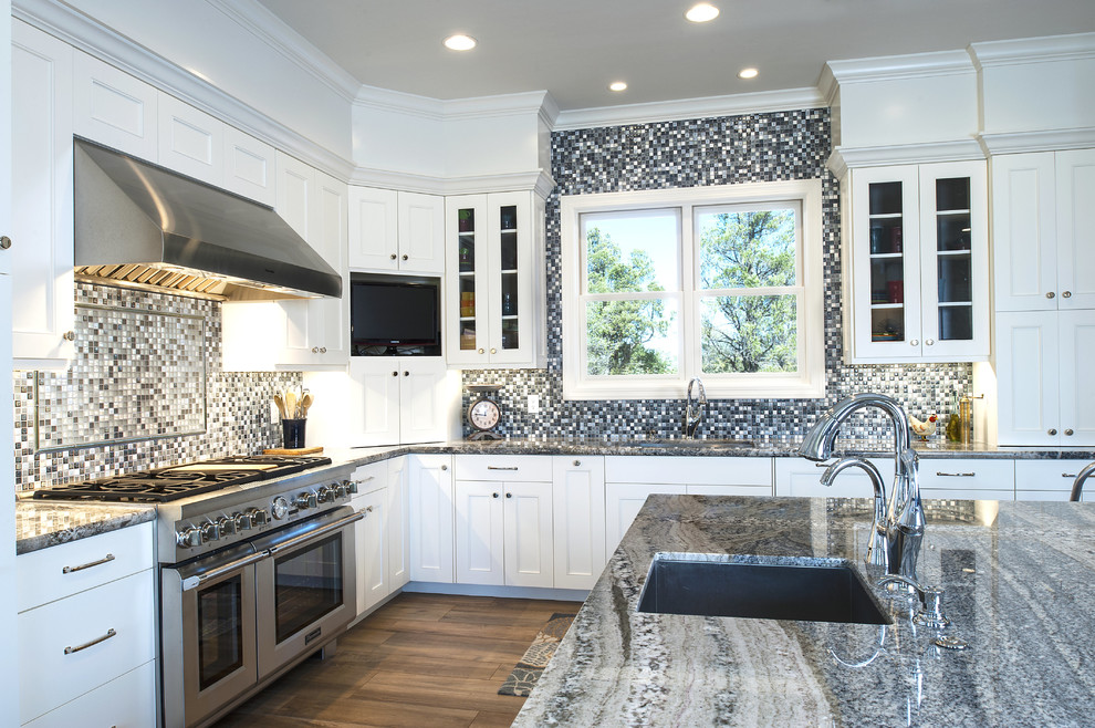 Example of a large transitional l-shaped ceramic tile and brown floor eat-in kitchen design in Phoenix with a single-bowl sink, shaker cabinets, white cabinets, granite countertops, blue backsplash, mosaic tile backsplash, stainless steel appliances and an island