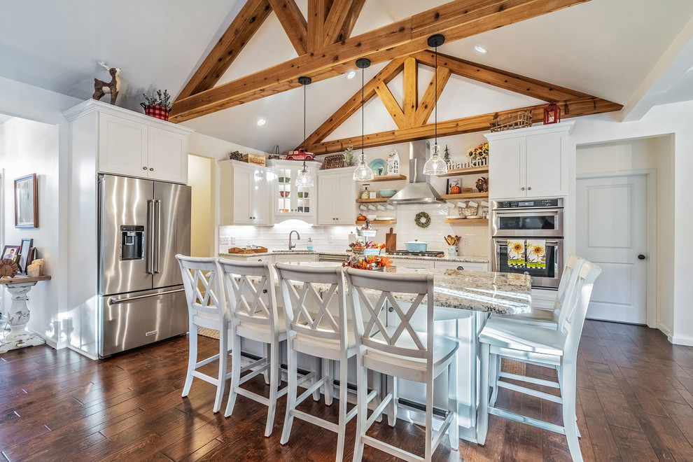 Eat-in kitchen - large country l-shaped medium tone wood floor eat-in kitchen idea in New York with an undermount sink, shaker cabinets, white cabinets, quartz countertops, white backsplash, subway tile backsplash, stainless steel appliances and an island