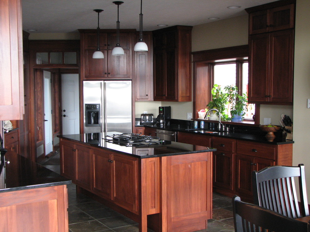 シカゴにあるトラディショナルスタイルのおしゃれなアイランドキッチン (御影石カウンター、シルバーの調理設備、スレートの床) の写真