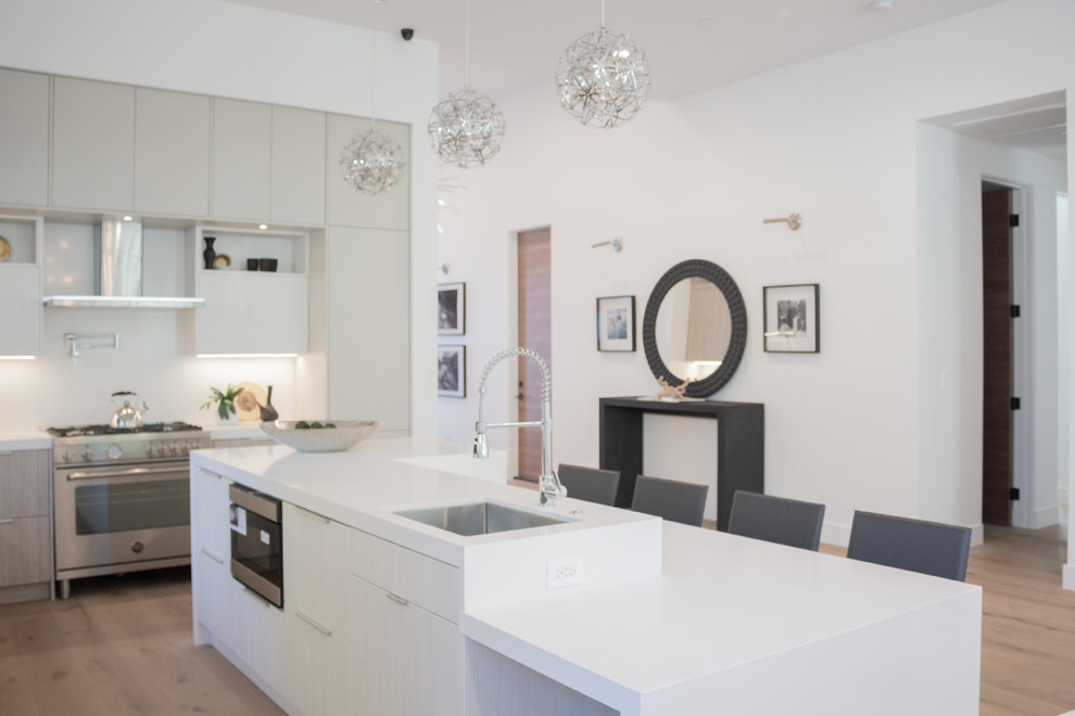 Esempio di una piccola cucina minimal con lavello integrato, ante lisce, ante grigie, top in quarzite, paraspruzzi bianco, pavimento in laminato, pavimento marrone e top bianco