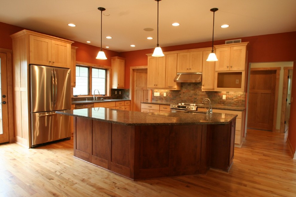 Immagine di una cucina stile americano con ante in legno chiaro, top in granito, elettrodomestici in acciaio inossidabile e parquet chiaro