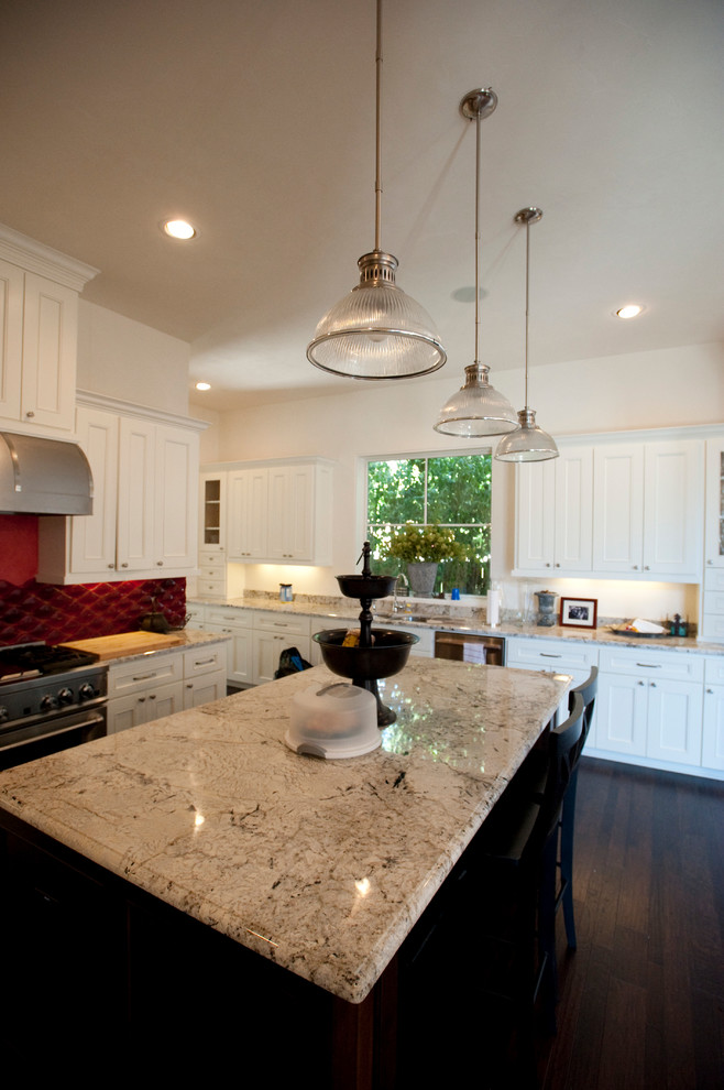 Mediterrane Küche mit weißen Schränken, Küchenrückwand in Rot, Rückwand aus Glasfliesen, Küchengeräten aus Edelstahl und dunklem Holzboden in Austin
