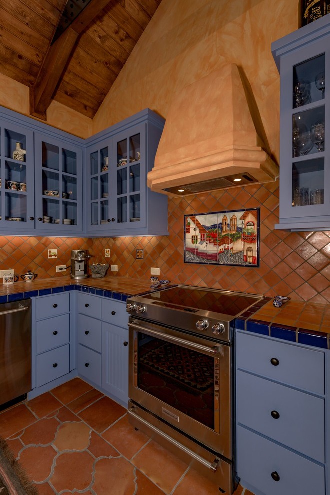 Esempio di una cucina american style di medie dimensioni con lavello sottopiano, ante lisce, ante blu, top piastrellato, paraspruzzi marrone, paraspruzzi con piastrelle in terracotta, elettrodomestici in acciaio inossidabile, pavimento in terracotta e pavimento marrone