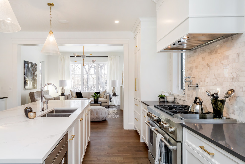 Inspiration for a medium sized traditional galley open plan kitchen in Other with a submerged sink, shaker cabinets, white cabinets, quartz worktops, white splashback, marble splashback, white appliances, medium hardwood flooring and an island.