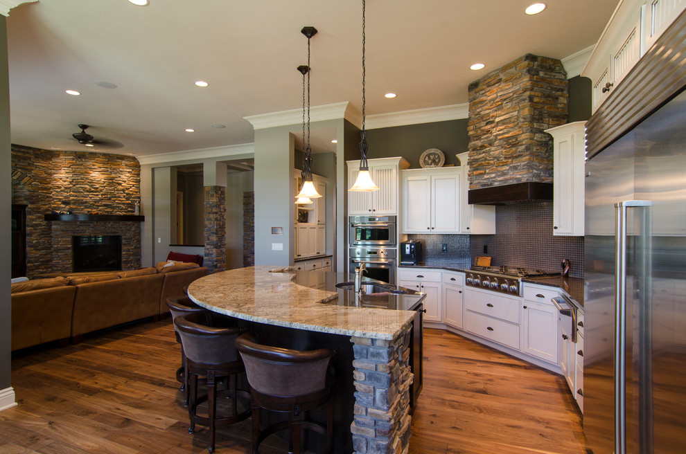 Exempel på ett stort modernt kök, med en dubbel diskho, skåp i shakerstil, vita skåp, granitbänkskiva, stänkskydd med metallisk yta, stänkskydd i keramik, rostfria vitvaror, mellanmörkt trägolv och en köksö