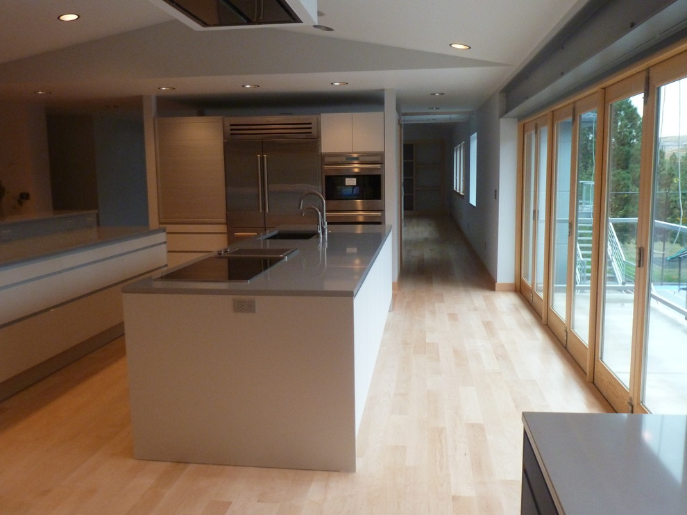 Exempel på ett stort modernt linjärt kök och matrum, med grå skåp, rostfria vitvaror, ljust trägolv, flera köksöar, en undermonterad diskho, släta luckor och bänkskiva i koppar