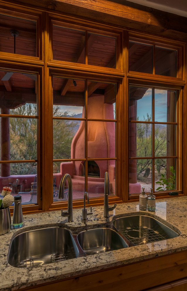 Exempel på ett avskilt amerikanskt kök, med en trippel diskho, luckor med infälld panel, bruna skåp, granitbänkskiva, rostfria vitvaror, klinkergolv i terrakotta och rosa golv