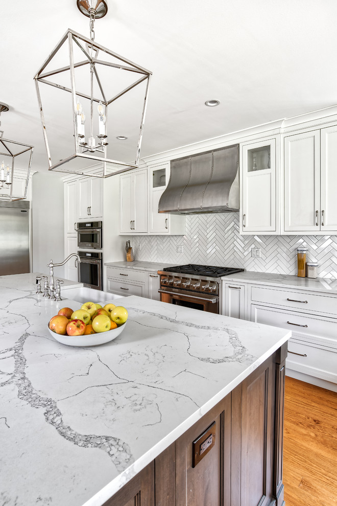 Inspiration for a huge timeless galley medium tone wood floor eat-in kitchen remodel in New York with a farmhouse sink, beaded inset cabinets, white cabinets, quartzite countertops, white backsplash, subway tile backsplash, stainless steel appliances, an island and white countertops