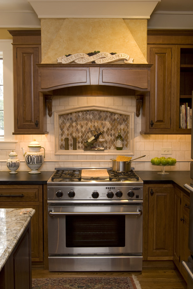 Immagine di una cucina tradizionale con elettrodomestici in acciaio inossidabile, top in saponaria e paraspruzzi beige
