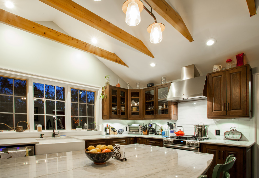 Example of a large arts and crafts l-shaped slate floor enclosed kitchen design in Philadelphia with a farmhouse sink, raised-panel cabinets, dark wood cabinets, quartzite countertops, white backsplash, subway tile backsplash, stainless steel appliances and an island