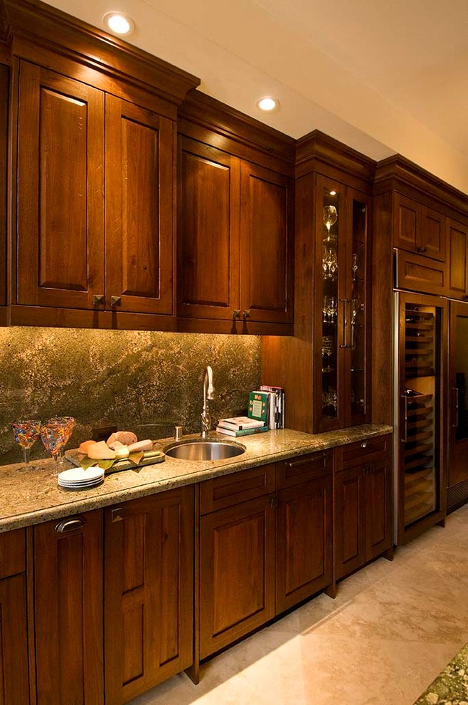 This is an example of a medium sized world-inspired u-shaped open plan kitchen in Hawaii with a submerged sink, raised-panel cabinets, medium wood cabinets, granite worktops, green splashback, stone slab splashback, integrated appliances, travertine flooring, an island, beige floors and green worktops.