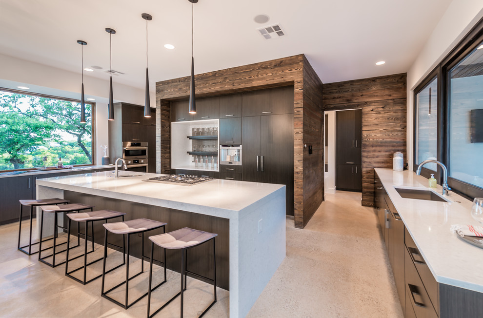 This is an example of a large contemporary u-shaped open plan kitchen in Austin with a single-bowl sink, flat-panel cabinets, dark wood cabinets, composite countertops, beige splashback, glass tiled splashback, integrated appliances, concrete flooring and an island.