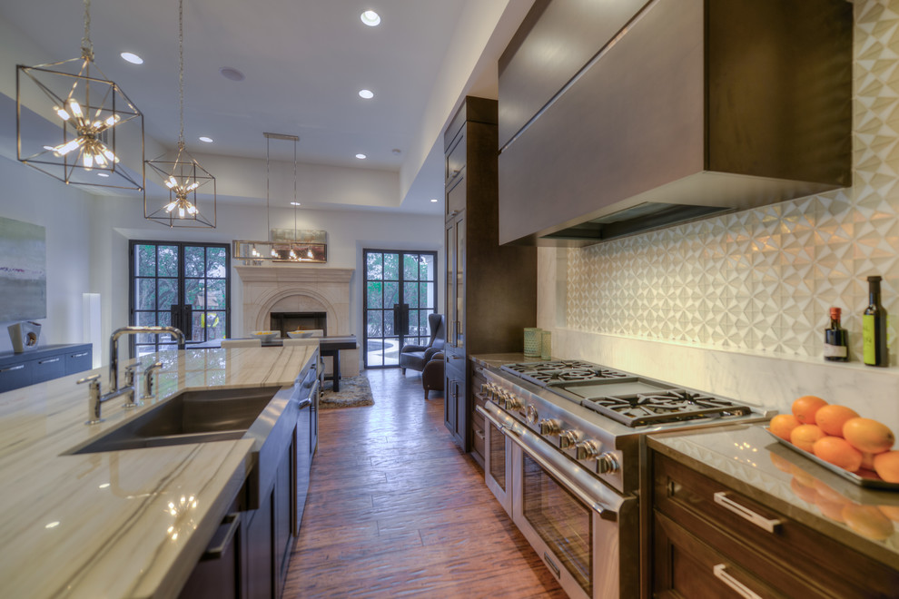 Example of a large transitional l-shaped light wood floor open concept kitchen design in Austin with a farmhouse sink, flat-panel cabinets, medium tone wood cabinets, marble countertops, white backsplash, stone tile backsplash, stainless steel appliances and an island