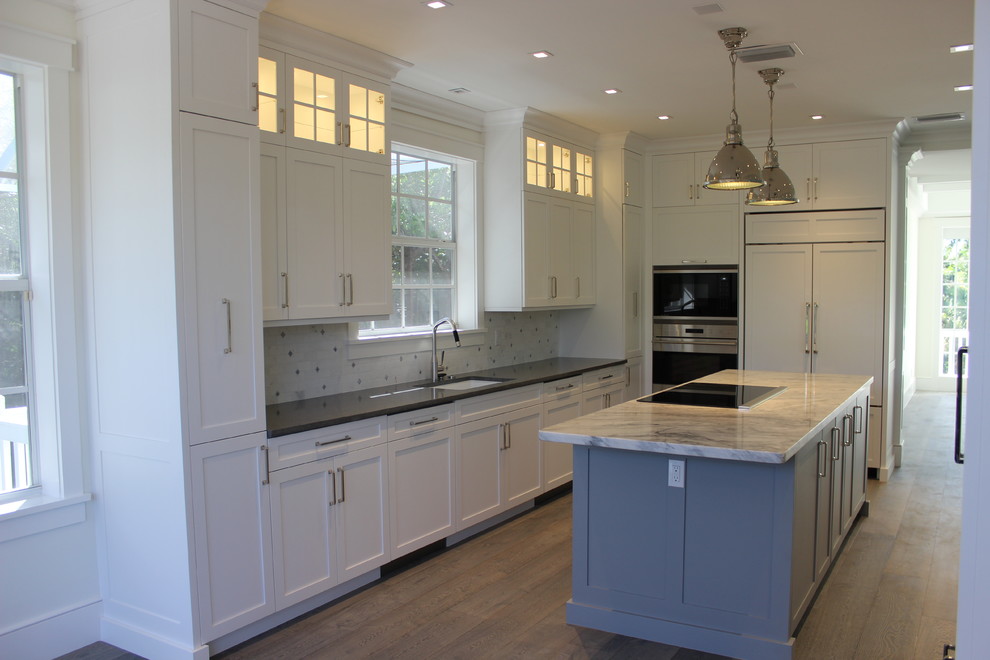 Example of a large transitional gray floor eat-in kitchen design in Other with shaker cabinets, white cabinets, marble countertops, gray backsplash, stone tile backsplash, paneled appliances and an island