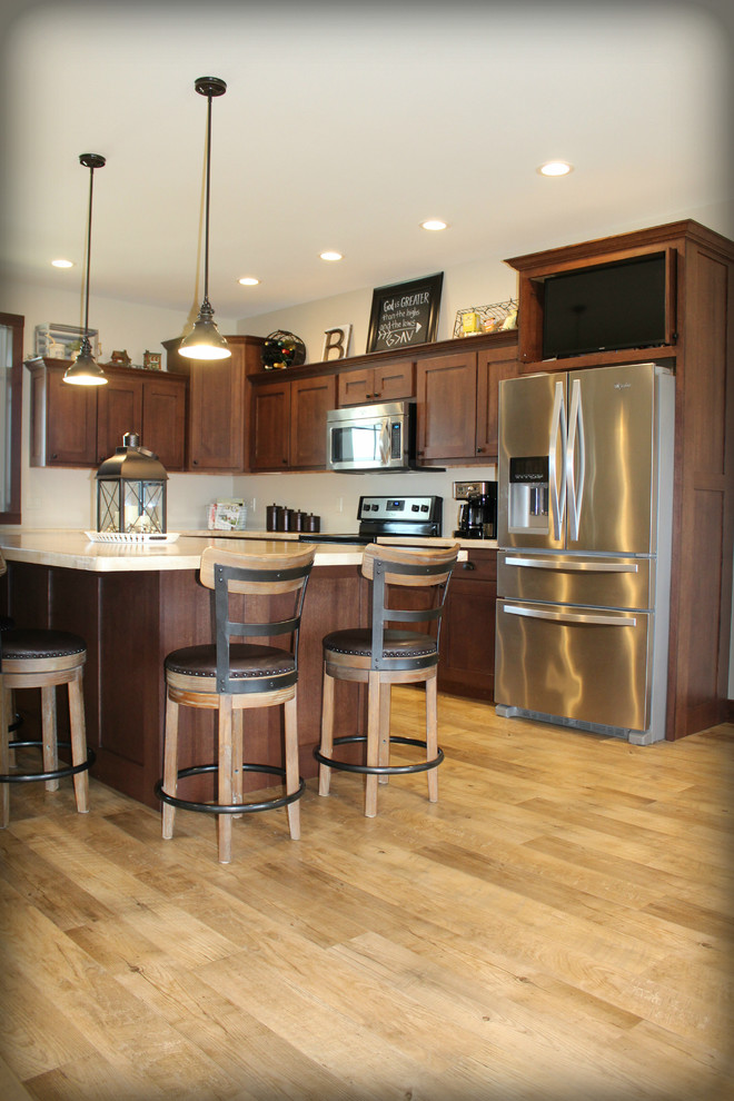 Foto på ett mellanstort vintage kök, med släta luckor, bruna skåp, bänkskiva i betong, rostfria vitvaror, ljust trägolv, en köksö, beiget golv och en undermonterad diskho