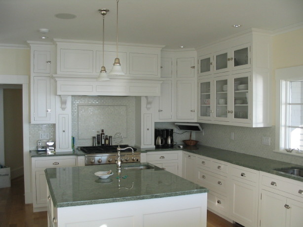Immagine di una grande cucina chic con lavello a doppia vasca, ante bianche, elettrodomestici in acciaio inossidabile, pavimento in legno massello medio e ante a filo